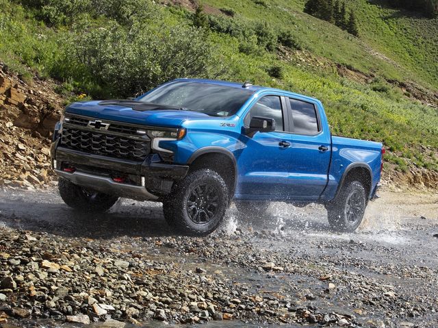 A 2024 Chevy Silverado 1500 drives through a stream.